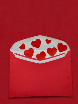 On red background red envelope filled with hearts. Stock Photos