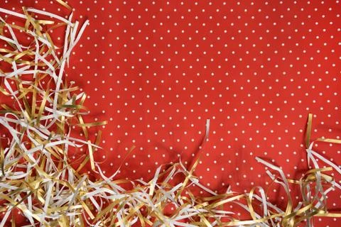 Red background with small white dot with Christmas tinsel. Stock Photos