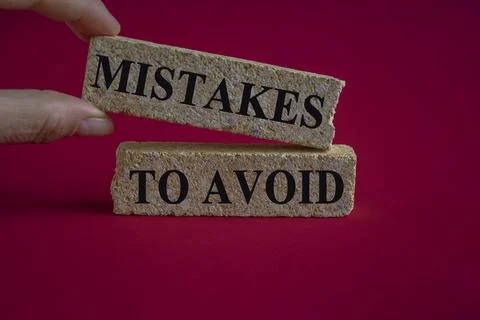 On red background, there are two brick blocks with the text MISTAKES TO AVOID Stock Photos