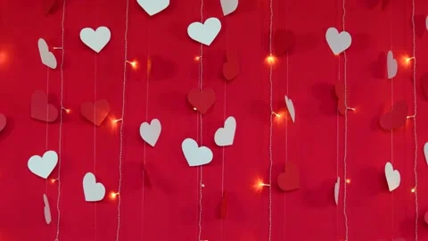 Red background with white hearts and flashing garland lamps. Camera movement Stock Footage 168109196