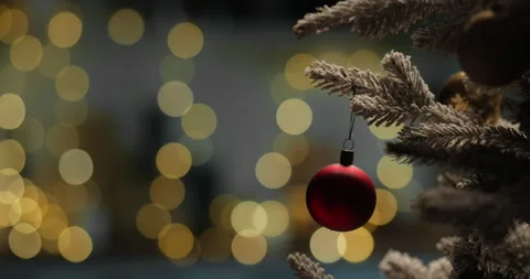 Red ball on a Christmas tree on a blurry bokeh background with lights particles Stock Footage 293740711