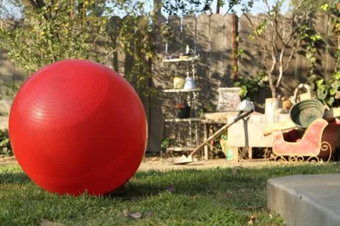 Red ball in a creative back yard. Stock Photos