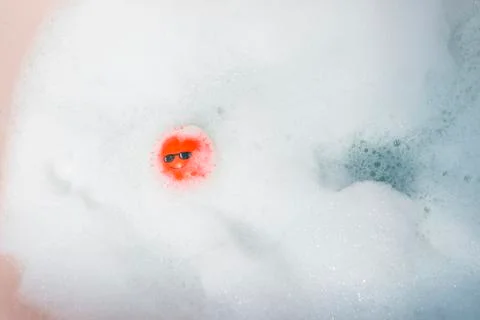Red ball floating in a bubble bath. Stock Photos