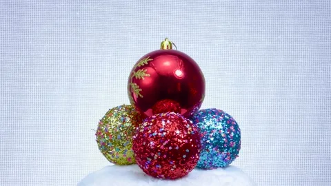 Red ball with a snowflake and three balls decorated with stars revolve Video stock 160785239
