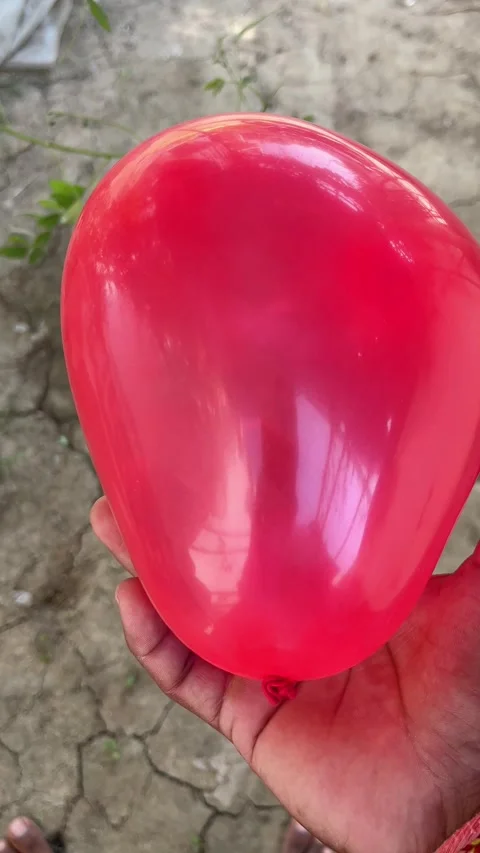 Red Balloon Held in Hand and Shown Close to the Camera Vidéo 321388527