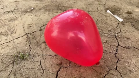 Red Balloon Lying on the Ground in Soft Natural Light Vidéo 321388519