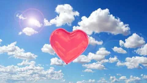 Red balloon in the shape of a heart flying in the sky Stock Footage 231488774