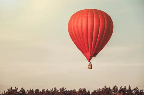 Red balloon in the sky with forest in the down Foto stock