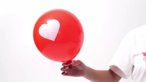 Red balloon with white heart on white background, girl holding balloon, festive Stock Footage 238926041