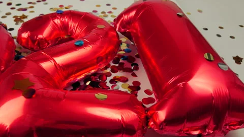 Red balloons in the form of numbers on a white background, falling confetti Stock Footage 144690855