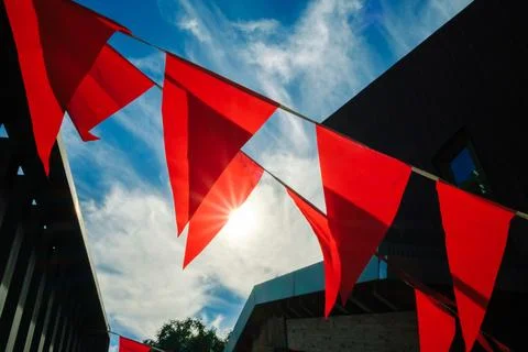 Red banners flutter in the sky, adding joy to the bustling public space below. Stock Photos