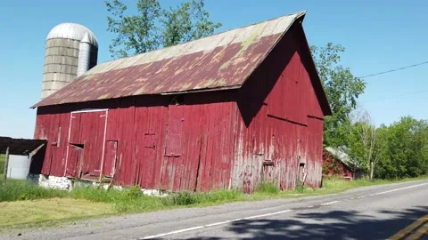 Red barn near highway tracking cars in the mirror 4K Stock Footage 133564902