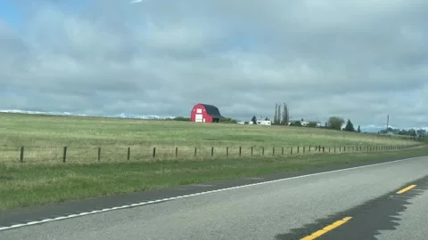 A red barn on the side of a rural highway Stock Footage 316744137