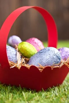 Red basket with chocolate easter eggs Foto stock