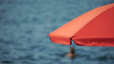 Red Beach Parasol umbrella on blue sky and sea background Red beach umbrella and Stock Footage 174132753