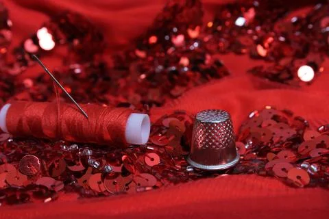 Red Beaded Fabric With Spool of Thread and Thimble Stock Photos
