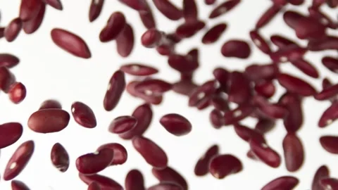 Red beans flying up on the white background slow motion Video stock 148553929
