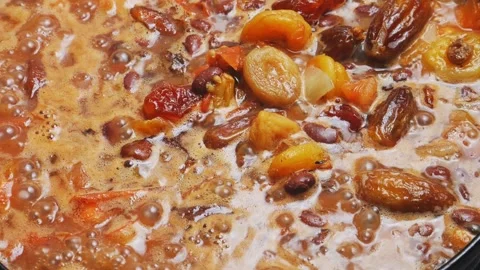 Red beans stewed in tomato sauce with dried fruits. Close-up. Stock Footage 296015979
