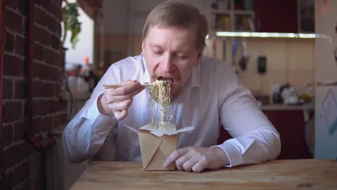 Red-bearded businessman eats instant noodles very hot and spicy. Stock Footage 104536542