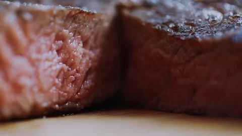 Red beef steak cooked medium well cut sliced knife on a cutting board roast Video stock 100304563