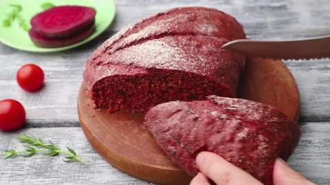 Red beet bread is cut with a knife. Stock Footage 137661051