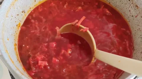 Red beet soup borscht in a saucepan is mixed with  ladle Stock Footage 241817776