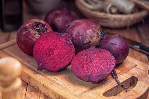 Red beetroot - beetroots on a cutting board and one cut in half, on the table Stock Photos