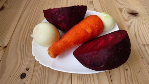 Red beetroot, carrots and onions rotate on a white plate. Stock Footage 229261730