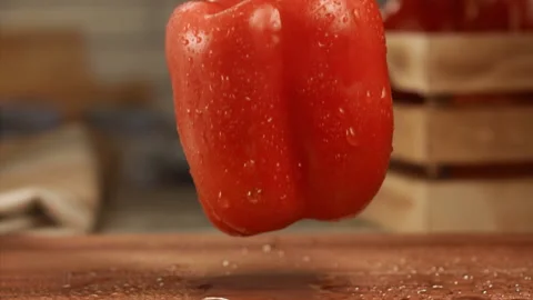 Red bell bell pepper falling on cutting board in slow motion Stock Footage 152905062