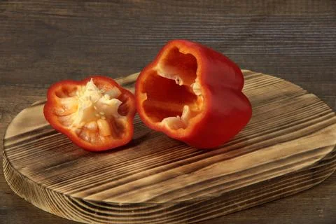 Red bell pepper cut in two on a cutting board. Foto stock