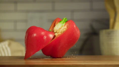 Red bell pepper falling on a table in slow motion Stock Footage 152904720