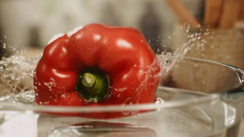 Red bell pepper falling into water in slow motion Stock Footage 152904685
