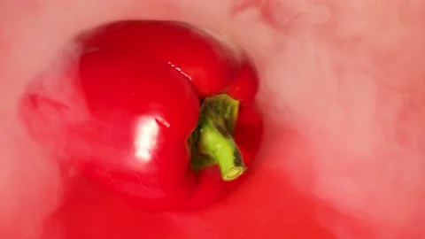 Red bell pepper lies on a red background, there is smoke around it Stock Footage 194531910