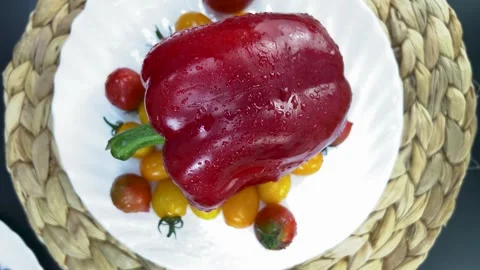 Red bell pepper rotating on a bed of cherry tomatoes Stock Footage 286698748