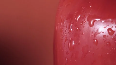 Red bell pepper spray close up, drops of water going down, orange background Stock Footage 102569653