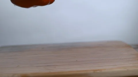 Red bell peppers falling and bouncing over chopping board in slow motion Stock Footage 100008061