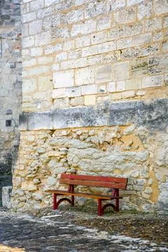 A red bench is sitting on a stone wall in Cognac France Stock Photos