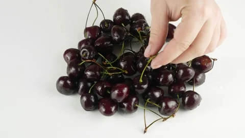 The red berries on a white table.Ripe cherry with green branches. Stock Footage 134594458