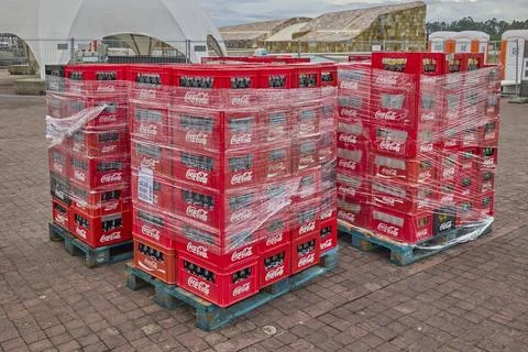 Red beverage crates stacked on pallets for outdoor event distribution Stock Photos
