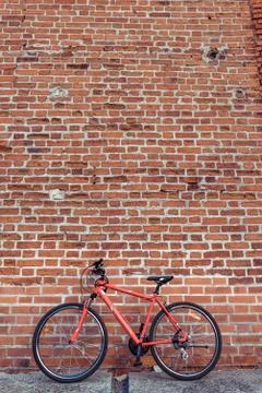 Red bicycle on the background of a brick old wall. Free space for text. The Stock Photos