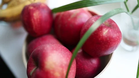 Red big apples on the table with bananas and palm branch in a glass Stock Footage 129709840
