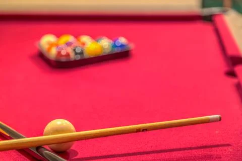 Red billiard table with balls and cue sticks Stock Photos