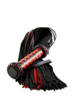 Red-black floger with a patterned handle and leather tails. vertical photo on Stock Photos