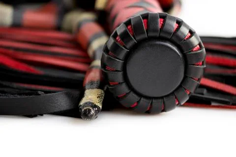 Red-black floger with a patterned handle and leather tails and young Scarlet  Stock Photos