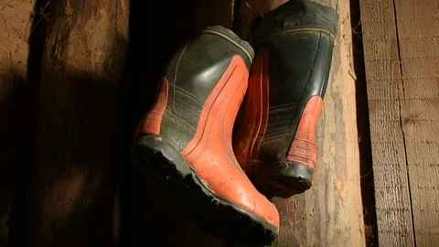 Red-black rubber boots on the wall of a wooden room Stock Footage 122009894