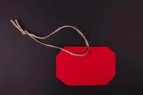 Red blank tag with string on black background Stock Photos