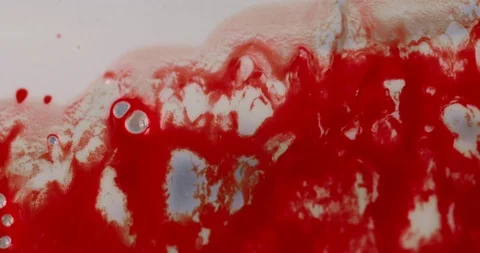 Red blood with bubbles running down a viscous white surface 4K Stock Footage 96272447