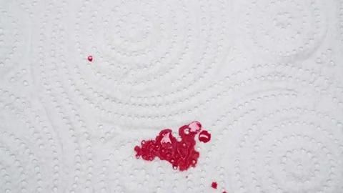 Red blood dripping down is absorbed into the white paper napkin. Video stock 161606148