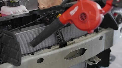 Red blower clears debris from EV car radiator 库存影片 339050405