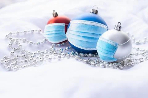 Red, blue and silver Christmas baubles with blue surgical face masks Foto stock